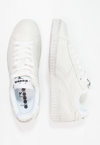Vita läder sneakers med en texturerad yta, med rund snörning, en vadderad krage och en mönstrad gummisula. Logotyp på tungan.