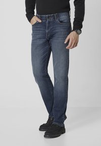 Dunkelblaue Jeans aus Denim mit geradem Bein, fünf Taschen, metallischem Knopfverschluss und subtilen Ausbleichungen auf dem Stoff.