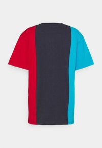 Tričko v barevných blocích s červenými, námořnickými a tyrkysovými částmi. Krátké rukávy, kulatý výstřih, vyrobeno z bavlněné směsi.