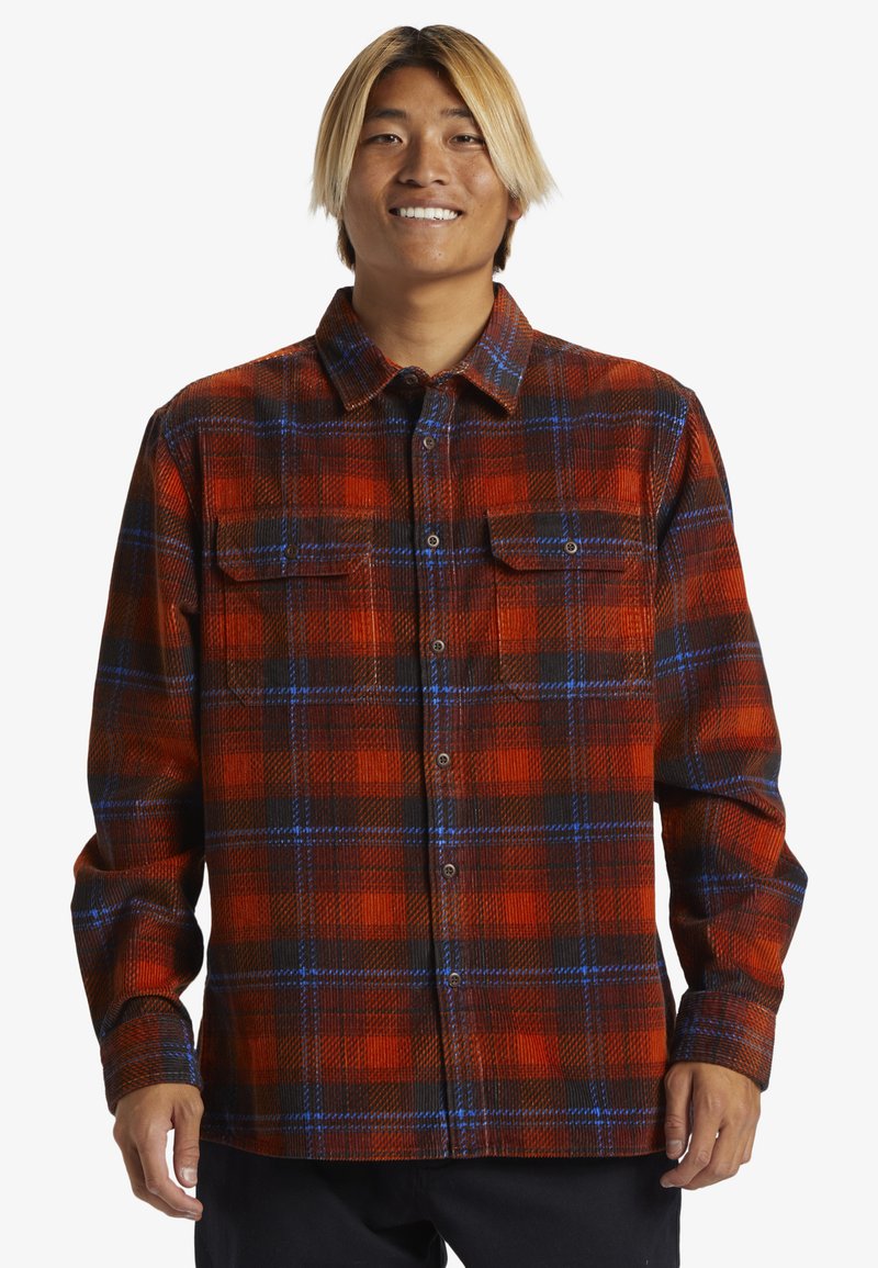 Rood- en zwart geruit flanellen shirt met blauwe accenten, knoopsluiting aan de voorkant, twee borstzakken en lange mouwen met knoopmanchetten.