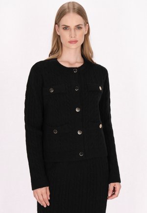 Schwarze Strickjacke aus Kabelmuster mit rundem Halsausschnitt, ausgestattet mit sechs silbernen Knöpfen und zwei vorderen Taschen, strukturiertem Stoff und tailliertem Schnitt.