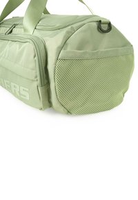 Bolsa de deporte verde con un panel lateral de malla texturizada, que cuenta con un cierre de cremallera y correas duraderas. Logo visible en el lateral.