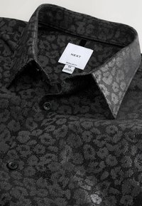 Czarna koszula w wzory o błyszczącym wykończeniu, z nadrukiem w panterę, z kołnierzykiem i czarnymi guzikami, oznaczona metką "NEXT".