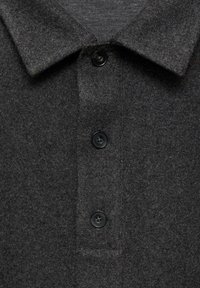 Polo shirt in lana grigia scura con placca bottonata, caratterizzato da un colletto pieghevole e una superficie morbida e tessurizzata.