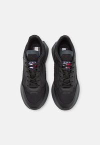 Baskets de sport noires avec une tige en mesh texturé, bout rond et accents de logo. Elles disposent de lacets noirs et d'une semelle rembourrée pour plus de confort.