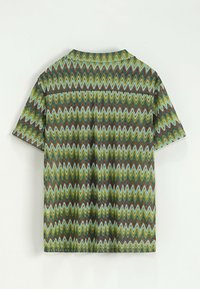 Chemise à manches courtes avec un motif en zigzag comportant des couleurs vertes, bleues et brunes. Fabriquée en tissu léger avec une coupe décontractée.
