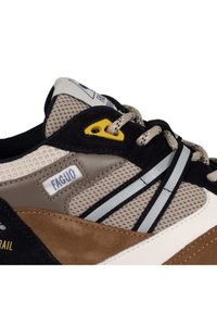 Herren-Sneaker mit einer Mischung aus beigem Mesh, dunkelblauem Wildleder und hellbraunen Akzenten. Enthält graue Streifen und eine gelbe Öse.