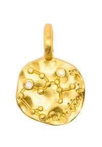 Złoty wisiorek o teksturowanej, okrągłej powierzchni, z konstelacją Strzelca oznaczoną małymi kryształami i wygrawerowanymi detalami.
