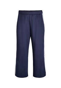 Námornícky modré športové nohavice s elastickým pásom, s bielymi bočnými pruhmi a voľným, skráteným strihom. Hladká textúra.