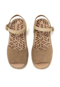 Sandalias de ante marrón con diseño de punta descubierta, correa ajustable y adornos trenzados en la suela. Patrón de hojas intrincado en la plantilla.