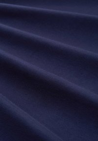 Tela de algodón azul marino, textura suave, superficie ligeramente arrugada, con color uniforme y sin patrones o adornos visibles.