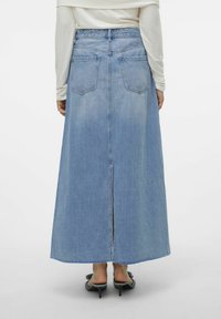 Modra denim krila z visokim pasom, dolge dolžine in razporkom na zadnjem delu. Dve zadnji žep in raztrgan rob dopolnjujeta zasnovo.