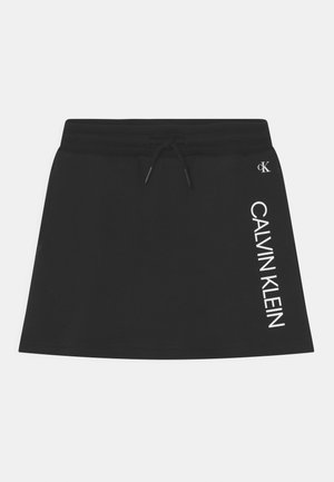 Zwarte katoenmix rok met een trekkoord in de taille. Heeft "CALVIN KLEIN" in het wit aan de zijkant gedrukt en een gladde textuur.