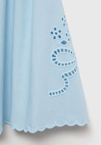 Vestido azul claro con bordado floral y un dobladillo con forma de ondas. La tela es suave, con recortes detallados y una costura intrincada.