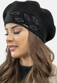 Berretto nero realizzato in materiale lavorato a maglia, decorato con perline in un motivo a foglia e un piccolo accento di marca sul lato.
