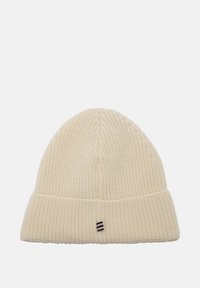 Bonnet tricoté de couleur crème avec une texture côtelée et un revers. Présente un petit logo cousu avec des rayures rouge, blanc et bleu.