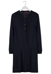 Robe noire à manches longues, longueur jusqu'aux genoux, avec col rond, boutons dorés sur la patte de boutonnage avant, suspendue à un cintre blanc sur fond blanc.