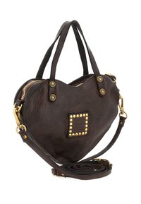 Borsa a forma di cuore in pelle marrone scuro con doppi manici, borchie dorate attorno all'etichetta frontale, chiusura con zip e tracolla removibile.