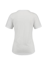 Camiseta blanca de manga corta hecha de algodón, con un cuello redondo y un dobladillo ligeramente curvado en la parte posterior. Diseño minimalista.