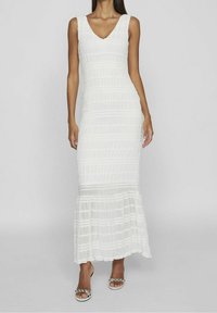 Vit klänning med V-ringning, figurnära liv och utsvängd nederkant. Det strukturerade tyget har horisontella ränder och en subtil lyster.