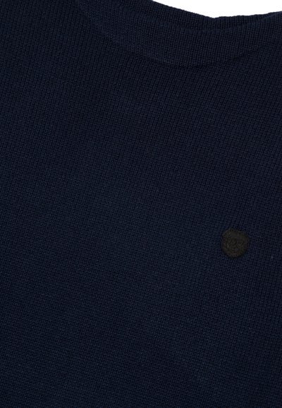 Marineblauer Strickpullover mit gerippter Textur, Rundhalsausschnitt und kleinem schwarzem Logo-Patch auf der linken Seite.