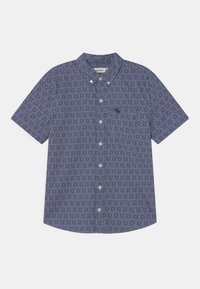 Camisa de manga corta con botones, estampado floral geométrico morado y pequeño logo de alce azul oscuro en el bolsillo del pecho.