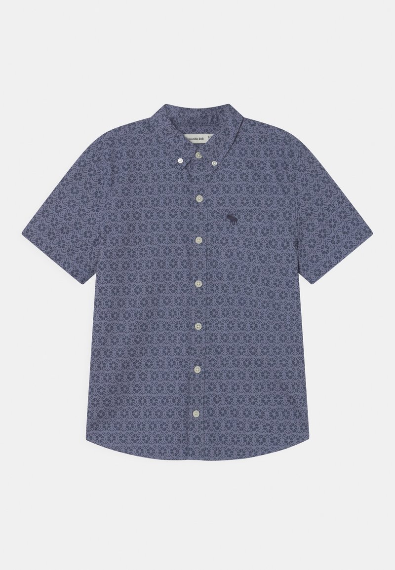 Camisa de manga corta con botones, estampado floral geométrico morado y pequeño logo de alce azul oscuro en el bolsillo del pecho.