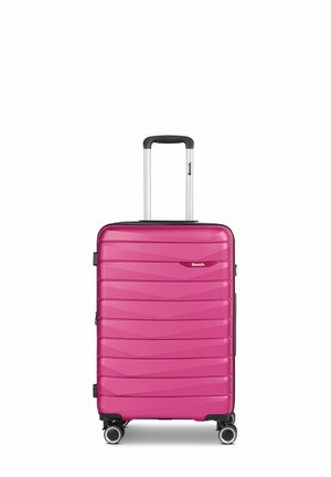 Hard-shell suitcase in vibrant pink with wavy texture. Features a telescoping handle, black accents, and four spinner wheels for mobility.