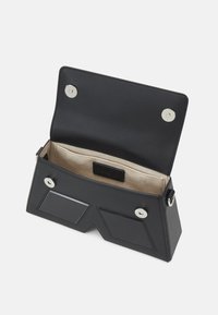 Black leather bag with a structured triangular design, magnetic snap closure, and beige interior. Features two card slots inside.