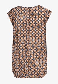 Tričko s krátkým rukávem vyrobené z látky s oranžovým, černým a bílým geometrickým vzorem. Volný střih s kulatým výstřihem a zakřiveným spodním lemem.