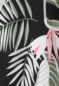 Motivo di foglie tropicali e fiori in verde tenue, bianco e rosa su uno sfondo di tessuto nero.