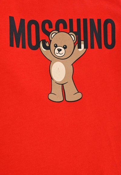 Czerwona bawełniana koszulka T-shirt z postacią kreskówkowego misia z uniesionymi rękami oraz napisem "MOSCHINO" dużymi czarnymi literami nad misiem.
