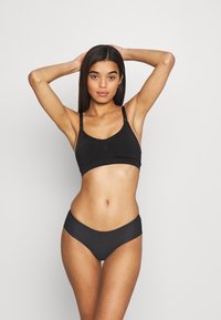 Fekete bralette és bikini szett sima textúrával, állítható pántokkal és egyszerű kialakítással, alacsony derékkal.