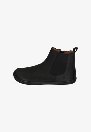 Black ankle boots made of suede, featuring elastic side panels, a round toe, and a textured rubber sole. Zipper detail at the back.