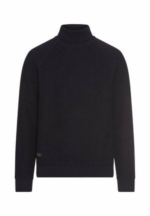 Navy turtleneck sweater with a textured knit pattern, raglan sleeves, and ribbed cuffs and hem. Includes a small branded tag at the bottom.