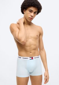 Ανοιχτό μπλε μπόξερ από απαλό ύφασμα, με ελαστική μέση σε μαύρο και άσπρο χρώμα, που φέρει το λογότυπο "TOMMY HILFIGER" και χρωματικές λεπτομέρειες.