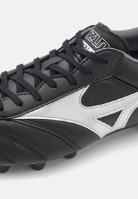 Crampon de fotbal negru din piele cu accente argintii, având un design elegant, suprafață texturată și șireturi tradiționale.