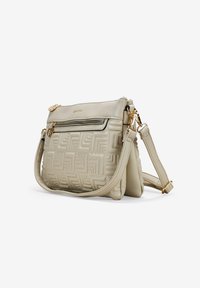 Bolso cruzado de color beige claro con patrón geométrico en relieve, herrajes dorados, compartimentos con cremallera y correa ajustable. Textura de cuero suave.