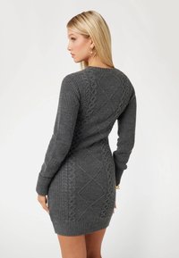 Abito maglione grigio in maglia con texture a coste, maniche lunghe e motivi a treccia. Vestibilità aderente con scollatura rotonda e orlo a coste.