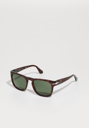 Tortoiseshell sunglasses with dark green lenses. Square-shaped frames, thin arms featuring silver hardware accents and slight texture variation.