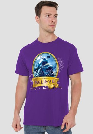 Man wearing purple T-shirt with "The Polar Express" design showing train on snowy mountain and text "BELIEVE I Do."