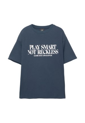 Mörkblå t-shirt med kort ärm med vit text: "SPELA SMART, INTE OANSVARIGT SPELDAG CHALLENGE", tillverkad av mjukt material med avslappnad passform.