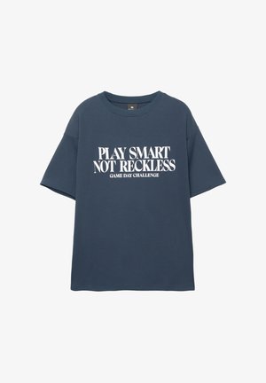 Mörkblå t-shirt med kort ärm med vit text: "SPELA SMART, INTE OANSVARIGT SPELDAG CHALLENGE", tillverkad av mjukt material med avslappnad passform.