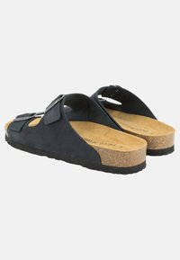 Sandali in suede nero con soletta in sughero, cinturini larghi e chiusure regolabili. Presentano una suola testurizzata per una migliore aderenza e supporto.
