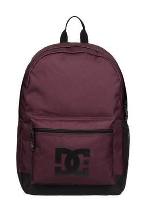 Sac à dos bordeaux avec logo DC noir, poche avant zippée, fond noir, poignée noire et poche latérale en mesh sur fond blanc.