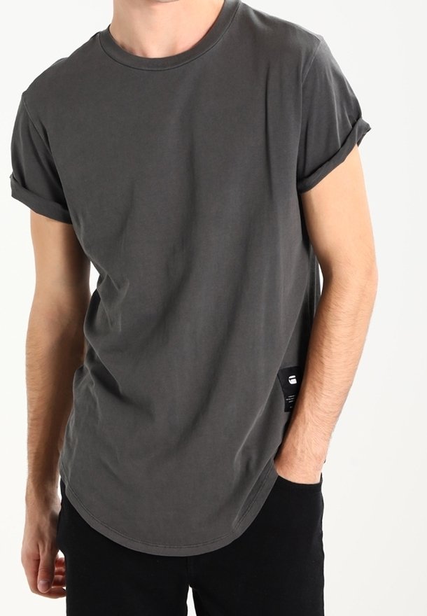 Šedé bavlněné tričko s ohrnutými rukávy, kulatým výstřihem a zakřiveným lemem. Obsahuje malou značkovou cedulku na boku. Hladká textura.