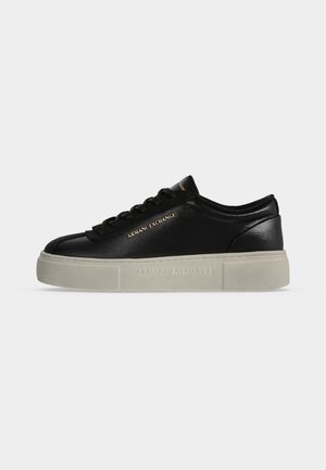 Czarny niski sneaker Armani Exchange z grubą białą podeszwą i złotym logo po boku i na języku, pokazany z profilu na białym tle.