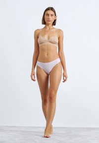 Beige Bralette und hellrosa Bikini-Höschen, weicher Stoff, minimalistisches Design, verstellbare Träger am Bralette, figurbetonte Form.