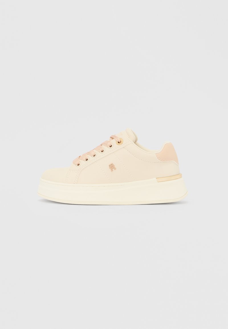 Bež superge z gladko teksturo, zaobljene oblike, kontrastnimi roza poudarki in grobo belo podplatom. Na luknjicah za vezalke imajo zlato kovinsko opremo.