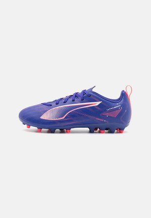 Scarpini da calcio viola con un upper testurizzato, logo bianco e accenti rosa. Presentano un design elegante e molteplici tacchetti per la trazione.